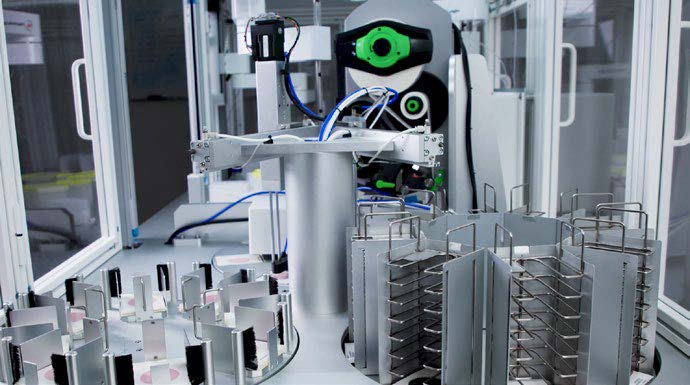 Robotic arm transferring inoculated films to sorted racks for incubation