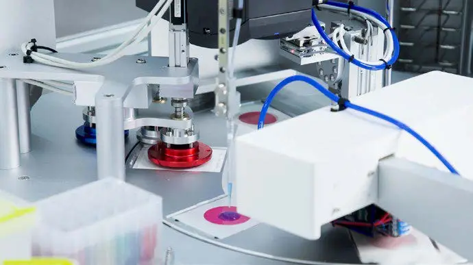 Automated pipetting head dispensing sample onto petrifilm inside the FX Machine